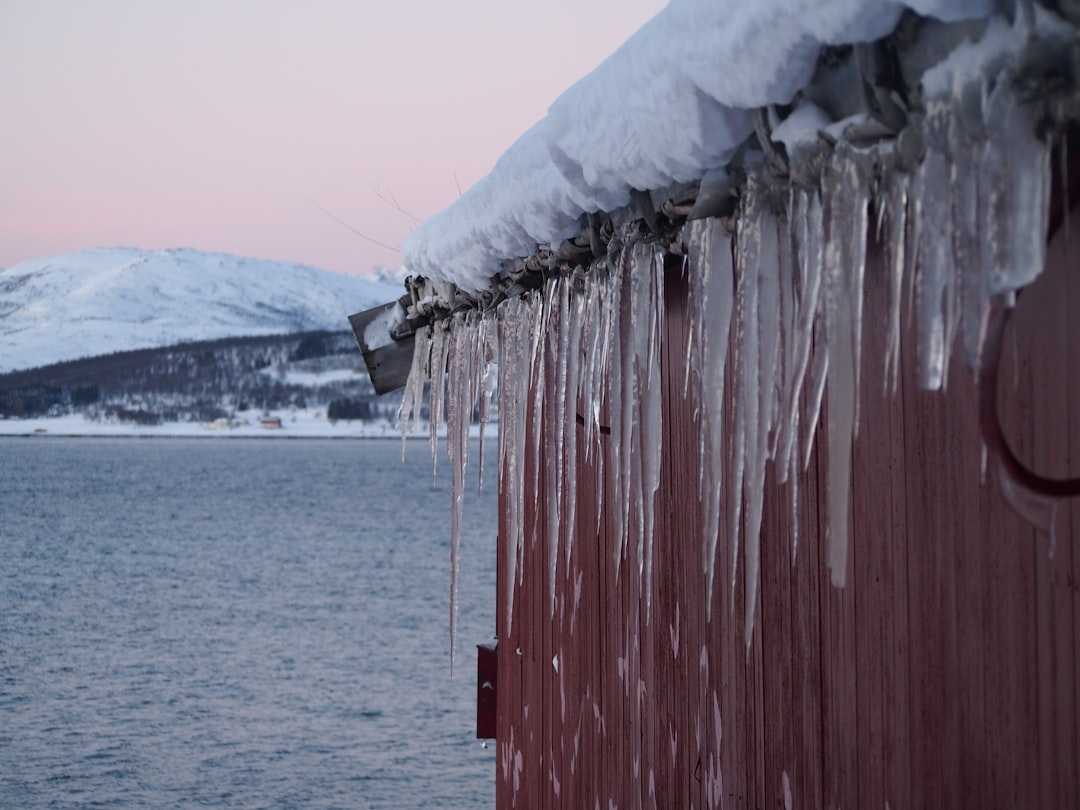 ice dam roof damage with icicles along gutters